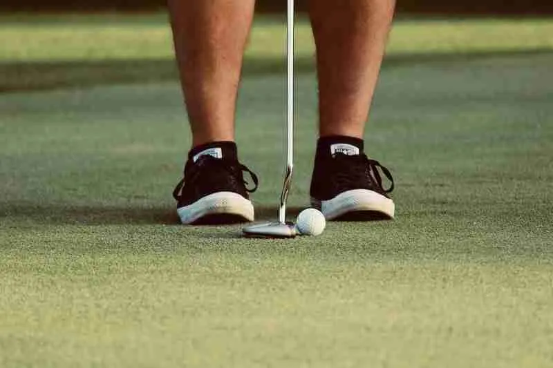 a golfer with minimalist shoes putting