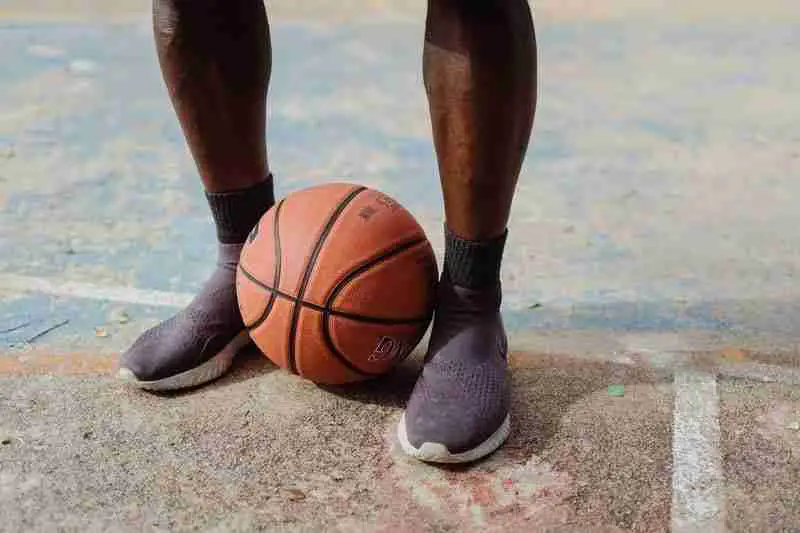 a man with basketball barefoot shoes and a basketball